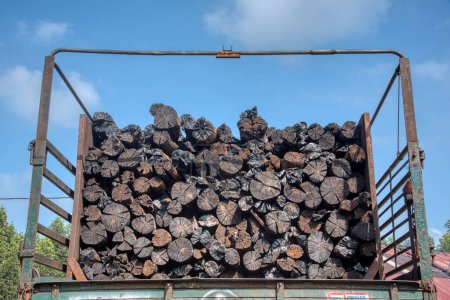 Behind view piles of charcoal woods stacked up on the lorry.