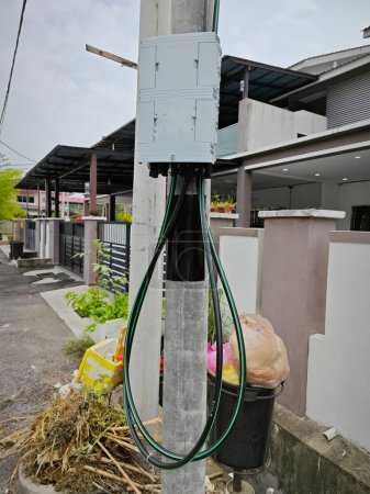 Escena de la caja de utilidad Unifi USW Flex al aire libre junto al poste de la calle.