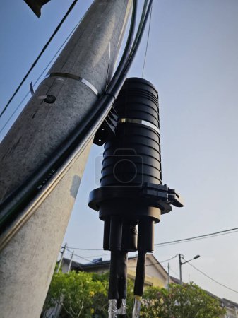 caja de refuerzo de potencia cilíndrica negra al aire libre por el poste de la calle.