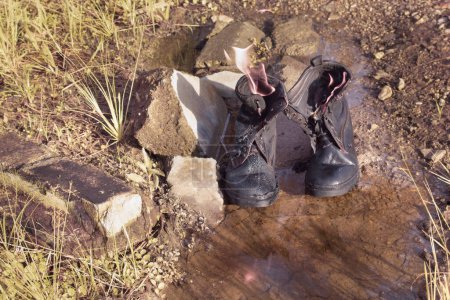 Infrarotbild alter weggeworfener Lederstiefel auf wilder Wiese gefunden.