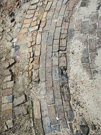 looking down the surface of damaged the damaged brick road