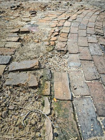 looking down the surface of damaged the damaged brick road