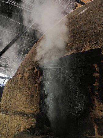 heller Rauch strömt aus dem Kohleofenaustritt zur Decke. 