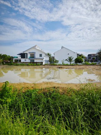 scene of a vacant reflective pool of stagnant rainwater land by the residential area.