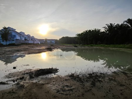 Szene eines leeren reflektierenden Pools aus stehendem schlammigem Regenwasser am Wohngebiet.