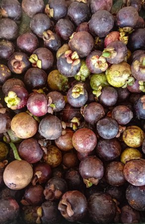 a group of fresh ripe purple mangosteen fruits in market