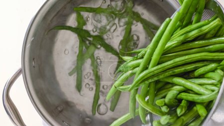Boiled green beans close-up. French sting beans, Haricots Verts, in a pot with boiling water, close up cooking process, recipe