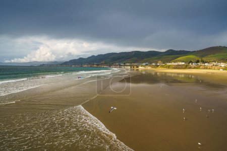 Foto de Amplia playa de arena, océano Pacífico tormentoso y cielo nublado. Playa de Pismo, Costa Central de California - Imagen libre de derechos
