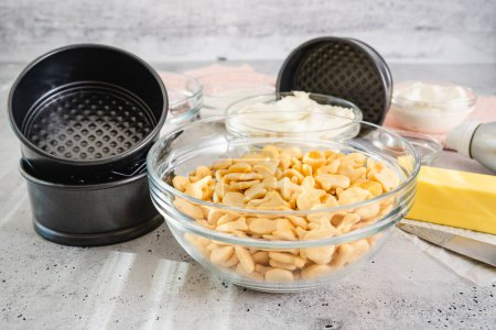 Foto de Receta de pastel de queso. Tres mini cacerolas redondas (estaño, molde), e ingredientes frescos para la receta de pastel de queso de cerca en la mesa de la cocina, la puesta plana - Imagen libre de derechos