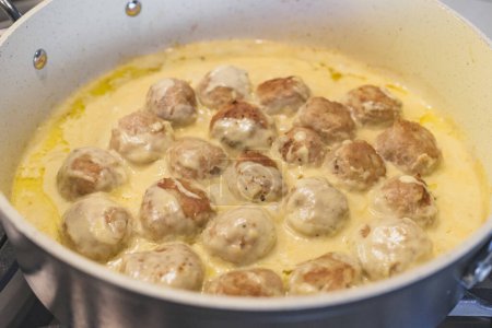 Photo for Sweadish meatballs in a creamy white sauce recipe. Meatballs close up on frying pan - Royalty Free Image