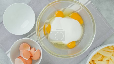 Téléchargez les photos : Mélanger les œufs et le sucre en gros plan dans un bol en verre. Recette gâteau aux pommes - en image libre de droit