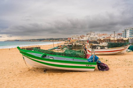 Foto de Barcos de pesca y equipo de la línea de la costa con un telón de fondo de una ciudad costera. Algarve, Portugal, 3 de enero de 2024 - Imagen libre de derechos