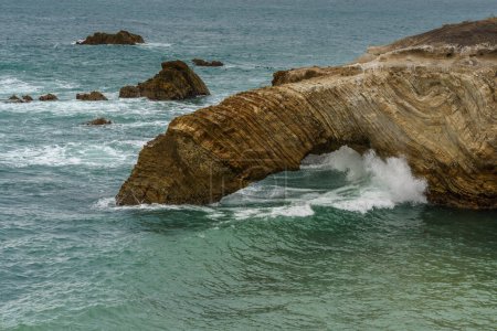 The rugged beauty of a rocky coastline meeting the vast expanse of the ocean under a dramatic sky, California Central Coast