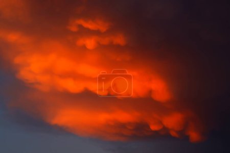 Téléchargez les photos : Nuages de mammifères se formant au coucher du soleil avant un orage violent - en image libre de droit