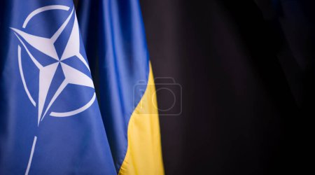 Téléchargez les photos : Ukraine, Kiev - 10.04.2023. Les drapeaux officiels de l'Ukraine et de l'OTAN sur fond noir. Symbole d'unité et de résilience dans un monde d'incertitude et de conflit. - en image libre de droit
