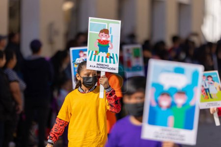 Téléchargez les photos : Matamoros, Tamaulipas, Mexique - 26 novembre 2022 : Le Desfile del 20 de Noviembre, Adultes et enfants portent des pancartes promouvant les droits des enfants pendant le défilé - en image libre de droit