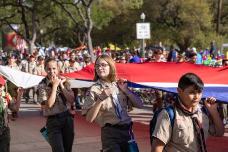 Foto de San Antonio, Texas, Estados Unidos - 8 de abril de 2022: Desfile de la Batalla de las Flores, miembros de los boy scouts que portan una bandera gigante de Texas - Imagen libre de derechos