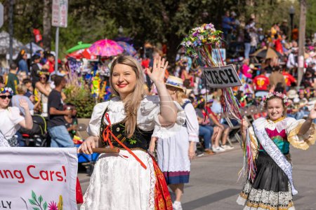Foto de San Antonio, Texas, Estados Unidos - 8 de abril de 2022: Desfile de la Batalla de las Flores, mujeres vestidas con ropa tradicional belga marchando por la calle durante el desfile - Imagen libre de derechos
