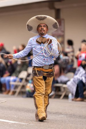 Foto de Brownsville, Texas, Estados Unidos - 26 de febrero de 2022: Charro Days Grand International Parade, miembro de los Vaqueros y Charros Unidos manejando un lazo durante el desfile - Imagen libre de derechos