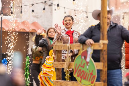 Foto de Brownsville, Texas, Estados Unidos - 26 de febrero de 2022: Charro Days Grand International Parade, mujer montada en una carroza con ropa mexicana tradicional - Imagen libre de derechos