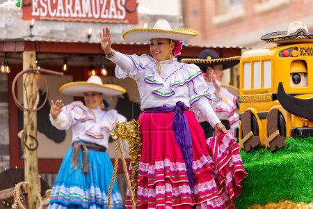 Foto de Brownsville, Texas, Estados Unidos - 26 de febrero de 2022: Charro Days Grand International Parade, mujeres vestidas con ropa tradicional de charro y sombreros saludando a los espectadores durante el desfile - Imagen libre de derechos
