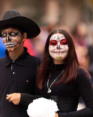 Téléchargez les photos : Matamoros, Tamaulipas, Mexique - novembre 1, 2022 : Dia de los Muertos Parade, Jeune homme et femme avec de la peinture sur le visage du crâne, regardez et souriez à la caméra - en image libre de droit