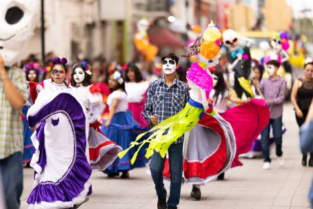 Téléchargez les photos : Matamoros, Tamaulipas, Mexique - novembre 1, 2022 : Dia de los Muertos Parade, les jeunes femmes et les hommes s'habillent en vêtements traditionnels dansant avec des marionnettes pendant le défilé - en image libre de droit
