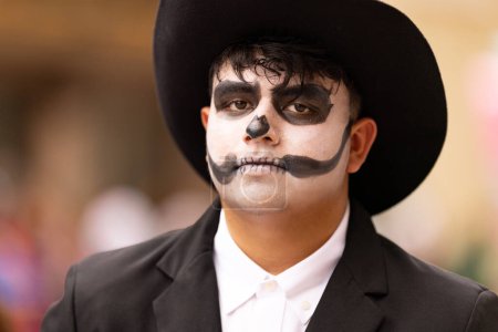 Téléchargez les photos : Matamoros, Tamaulipas, Mexique - novembre 1, 2022 : Dia de los Muertos Parade, Jeune homme portant de la peinture sur le visage du crâne, portant des vêtements traditionnels - en image libre de droit