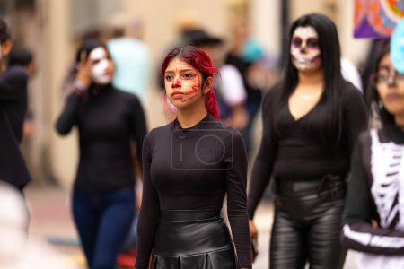 Téléchargez les photos : Matamoros, Tamaulipas, Mexique - 1 Novembre 2022 : Dia de los Muertos Parade, jeune femme utilisant de la peinture sur le visage du crâne - en image libre de droit