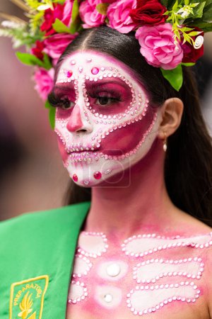 Téléchargez les photos : Matamoros, Tamaulipas, Mexique - novembre 1, 2022 : Dia de los Muertos Parade, Jeune femme habillée en catrina portant des vêtements traditionnels, sa robe de tête pleine de fleurs et le drapeau mexicain sur sa poitrine - en image libre de droit