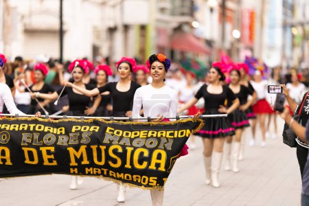 Photo for Matamoros, Tamaulipas, Mexico - November 1, 2022: Dia de los Muertos Parade, The Ricardo Flores Magon High School Cheerleaders performing at the parade - Royalty Free Image