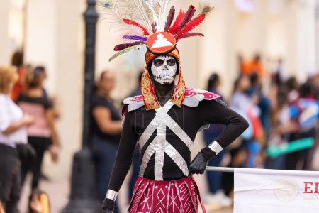 Foto de Matamoros, Tamaulipas, México - 1 de noviembre de 2022: Desfile del Día de los Muertos, Hombre joven disfrazado de nativo, y su cara pintada de cráneo - Imagen libre de derechos