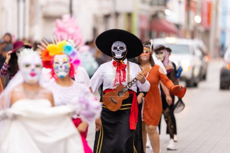 Foto de Matamoros, Tamaulipas, México - 1 de noviembre de 2022: Desfile de Dia de los Muertos, Vestido de mariachi con una máscara de cráneo y tocando una pequeña guitarra - Imagen libre de derechos