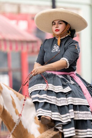 Foto de Matamoros, Tamaulipas, México - 16 de septiembre de 2022: Desfile 16 de Septiembre, Mujer joven vestida con ropa tradicional a caballo - Imagen libre de derechos