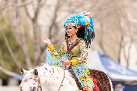 Foto de Laredo, Texas, Estados Unidos - 19 de febrero de 2022: Desfile de cumpleaños de Anheuser-Busch Washingtons, miembros del Consejo Princesa Pocachontas llevando ropa tradicional de nativos americanos, a caballo - Imagen libre de derechos