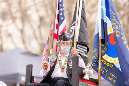 Téléchargez les photos : Laredo, Texas, États-Unis - Le 19 février 2022 : Le défilé d'anniversaire Anheuser-Busch Washingtons, flotteur transportant un vétéran de la guerre de Corée, agitant le drapeau américain - en image libre de droit