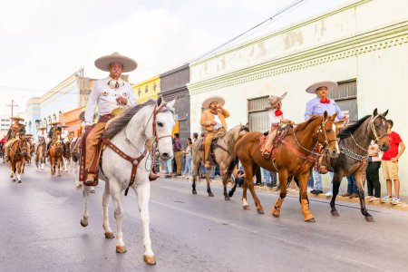 Photo for Matamoros, Tamaulipas, Mexico - February 25, 2023: Fiestas Mexicanas Parade, Men wearing traditional mexican clothing riding horses at the parade - Royalty Free Image