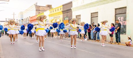 Téléchargez les photos : Matamoros, Tamaulipas, Mexique - 25 février 2023 : Fiestas Mexicanas Parade, Cheerleaders de l'Institut Technologique de Matamoros, vêtus de vêtements traditionnels, dansant au défilé - en image libre de droit
