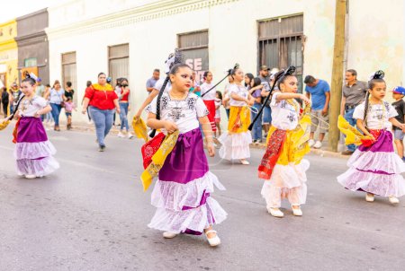 Foto de Matamoros, Tamaulipas, México - 25 de febrero de 2023: Desfile de Fiestas Mexicanas, Estudiantes de la Academia de Danza Xanadu vistiendo ropa tradicional, danicng en el desfile - Imagen libre de derechos