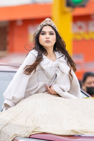 Foto de Valle Hermoso, Tamaulipas, México - 18 de marzo de 2023: Desfile del Aniversario de la Ciudad, Reina de la Belleza vistiendo su corona y un vestido tradicional, montando un vehículo durante el desfile - Imagen libre de derechos