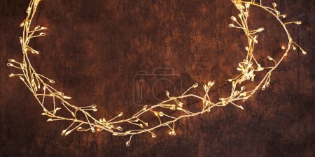 Foto de Christmas lights on adark woodeen background. Golden Xmas decorations glowin - Imagen libre de derechos