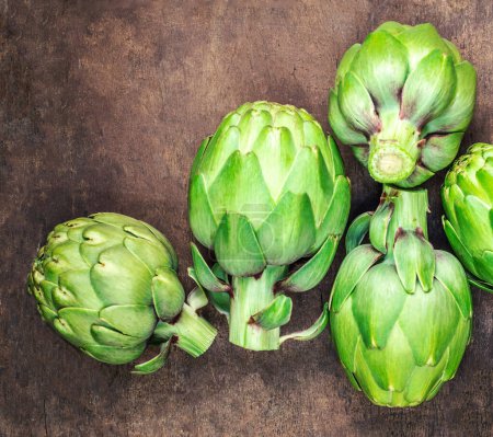 Photo for Artichoke flower buds. Fresh raw artichoke on wooden background close up - Royalty Free Image