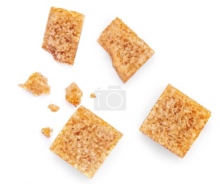 Foto de Brown sugar cubes isolated on white background. Cane sugar cubes with crumbs  Top view. Flat la - Imagen libre de derechos