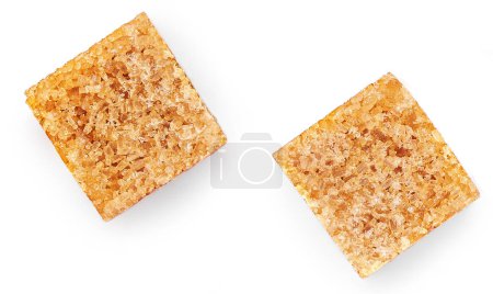 Foto de Trozos de azúcar de caña aislados sobre fondo blanco. Set de cubos de azúcar moreno con paja Vista superior. Piso la - Imagen libre de derechos