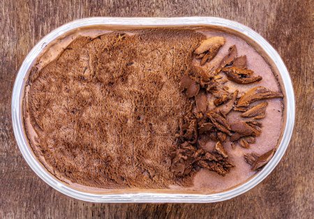 Photo for Chocolate icecream on a wooden rustic background. Dark chocolate  ice cream in a conteine - Royalty Free Image
