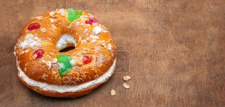 Téléchargez les photos : Gâteau Epiphany Roscon de Reyes sur fond bois. Dessert espagnol de trois rois gâteau mangé sur l'épiphanie da - en image libre de droit