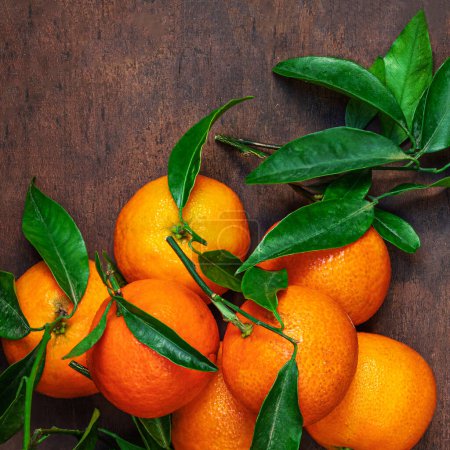 Téléchargez les photos : Oranges mandarines fraîches ou mandarines avec feuilles sur table rustique en bois, vue sur le dessus. Pose plate - en image libre de droit