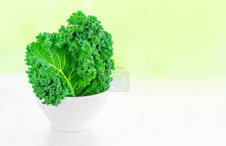 Photo for Fresh green kale in a bowl on a bright summer background. Creative layout - Royalty Free Image
