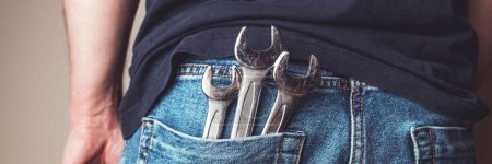 Téléchargez les photos : Homme avec des clés dans la poche arrière de sa bannière de jeans. Idéal pour les projets industriels, mécaniques et de bricolage. En-tête web panoramique. Papier peint grand écran. - en image libre de droit