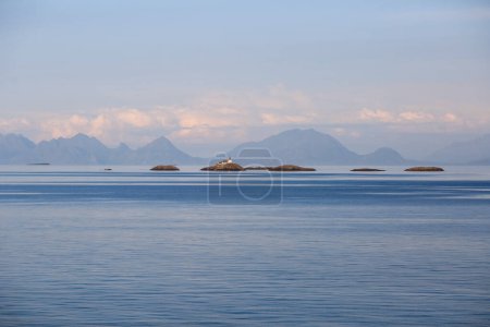 Photo for Lighthouse during summer sunset at the Lofoten islands, the photo taken from cruise liner Hurtigruta - Royalty Free Image